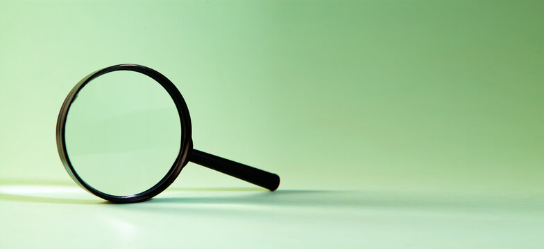 Magnifying glass on a green background.