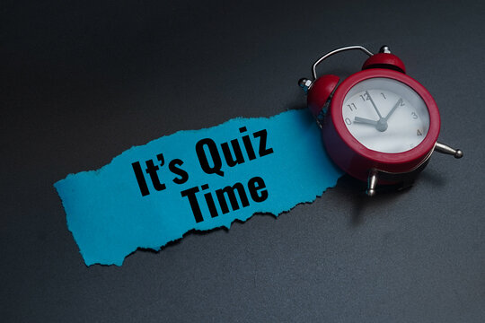 Red alarm clock on blue paper with its quiz time text.Education and trivia concept
