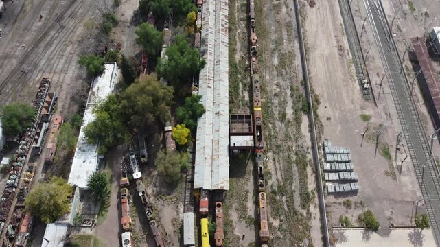 Aerial View of Abandoned Train Station with Rusting Trains in Ruins
