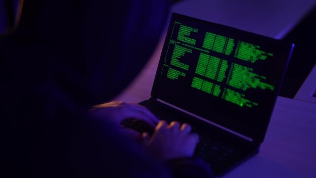 Cybersecurity professional executing penetration testing protocols on laptop. Ethical hacker typing malicious code syntax during targeted network vulnerability assessment.