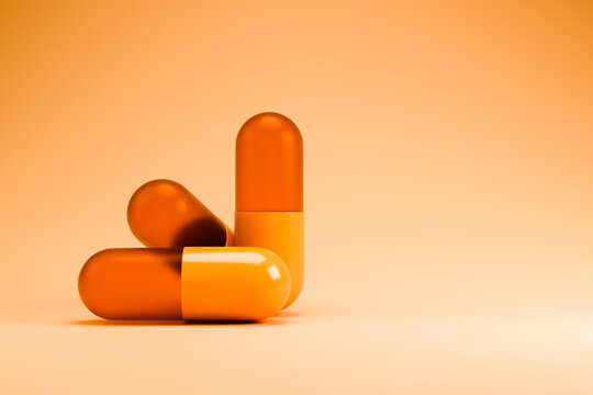 Orange and white medical capsules on orange background