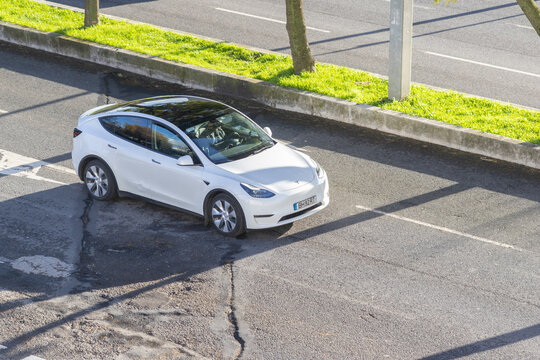 Tesla model y driving on urban road from aerial view
