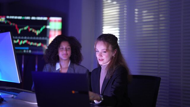 Senior software developers debugging complex backend cloud infrastructure code. Female data science engineers reviewing predictive AI algorithms on digital tablet and monitor.