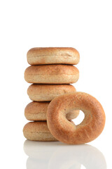 pile of whole wheat bagels with one leaning