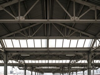 Interior perspective of a train station structure with iron beams overhead