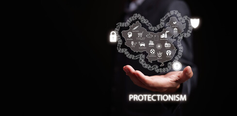 Protectionism concept. Hand holding a country surrounded by wall, lock, and shield protecting domestic industries in the country. Trade barriers, protective tariff, import quota, and subsidies.