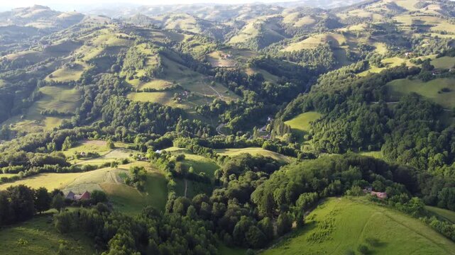 4K Aerial Drone Flight Over Green Hills with Houses and Forest in Transylvania, Romania, Peaceful Countryside