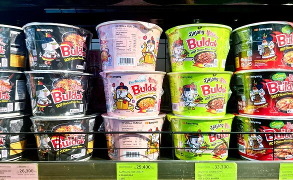 Jakarta, Indonesia - February 25th, 2026 - Samyang buldak instant noodle cup isolated on horizontal store shelf background.