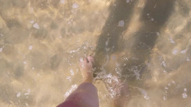 Woman's bare feet , a woman creating ripples on the surface of the water