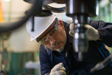 Professional technician checking industrial drill machine precision manufacturing factory....