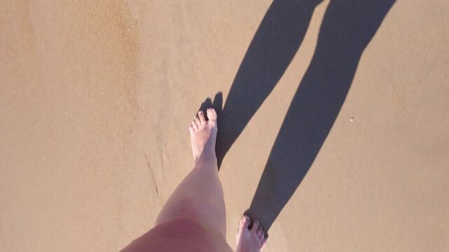 Bare feet of an overweight woman on the beach, woman walking along the shore