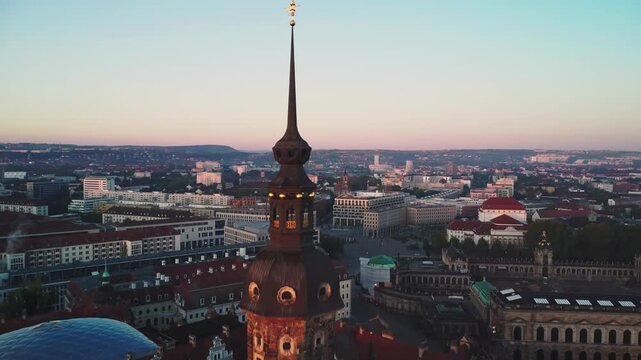 A pulling back aerial shoot of Cathedral of the Holy Trinity, also known as the Katholische Hofkirche with Dresden's Old Town  behind in Dresden in Germany at dawn
