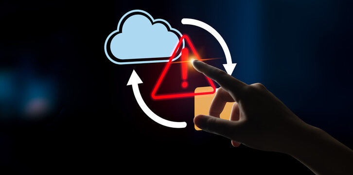 A hand reaching to an error alert symbol on a digital screen, representing the critical nature of cloud data management and the importance of cybersecurity awareness in modern technology. Gantry