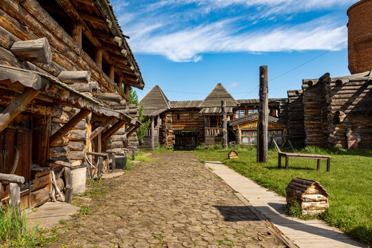 A reconstructed Old Slavic fortress, built of round, hewn logs. A bright sunny day. The courtyard is surrounded by living quarters.