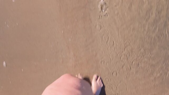Barefoot woman on the beach, woman walking along the shore
