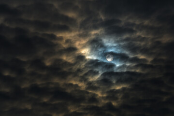 Fototapeta premium Bright Sun Disc Piercing Through Dark Heavy Clouds