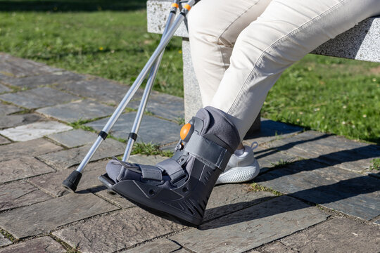 close up of a cam walker on a person with crutches resting from an ankle injury