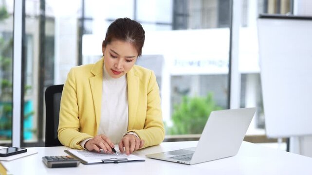 Businesswoman working in office, reading contract, sitting at desk. Realtor checking information about sale, rent or buying house.