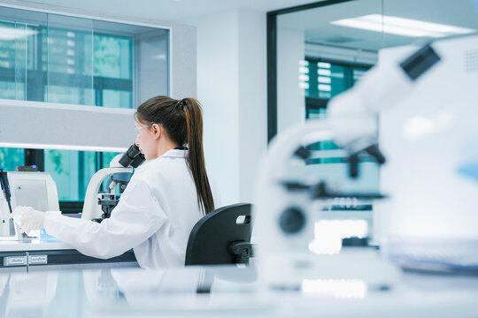 Pharmaceutical scientist validating pre-clinical drug discovery protocols via microscopic analysis. RD chemist inspecting compound formulation stability in sterile research center.