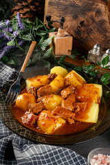 Pork stew in gravy with boiled potato.