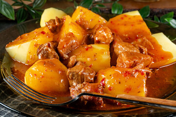 Pork stew in gravy with boiled potato.