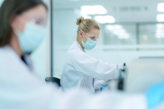Histopathology technician operating microtome for tissue biopsy sectioning. Biological researcher preparing histological specimen slides in sterile pathology lab.