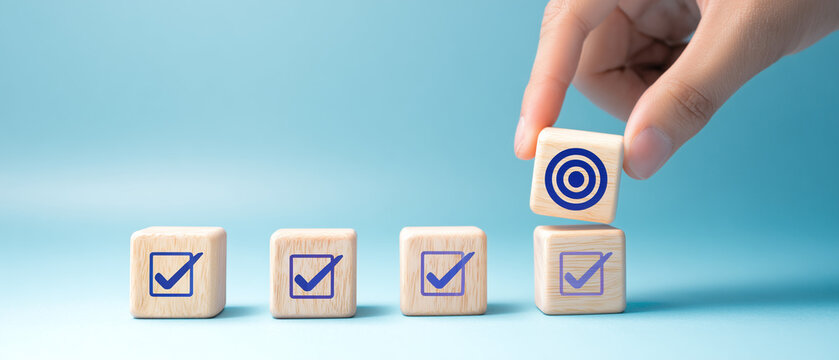 Blocos com marca de verifica&ccedil;&atilde;o e alvo simbolizando metas atingidas, organiza&ccedil;&atilde;o, planejamento e controle de qualidade.
