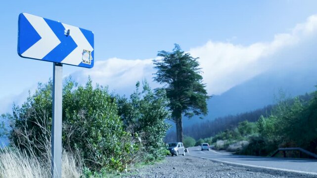 Road sign indicating a sharp right turn on a mountain pass