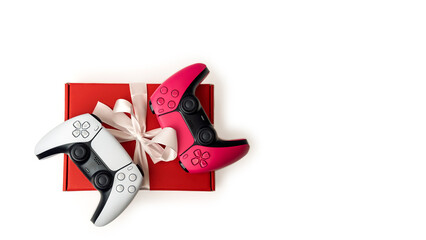 Gift box and gamepad joystick on a white background. White and pink joystick on a red gift box. Gift concept for a gamer or teenager © Om.Nom.Nom