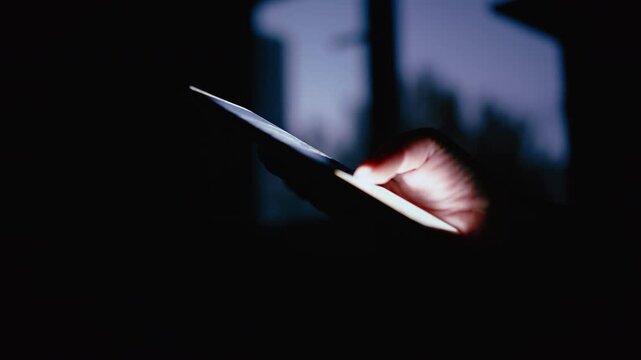 Womans Fingers Typing on Smartphone Screen Late at Night Beside Window