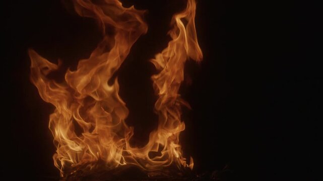 Fire flames on black backdrop. Fire texture. Blazing fire. Flame slow motion. Intense burning fire texture for overlay layer effects. Flame abstract design. Glowing flames.