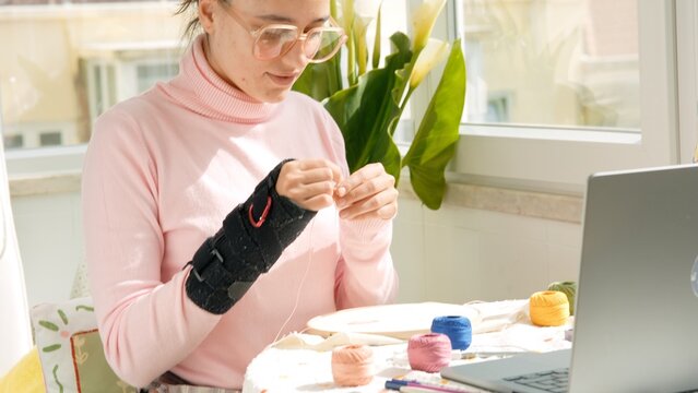 Seamstress engaged in detailed embroidery near windowlight
