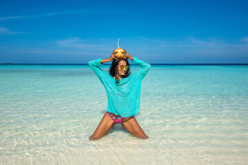 Woman posing and holding coconut. Tropical island beach landscape exotic shore coast. Summer vacation, holiday amazing nature. Relax paradise, Maldives.