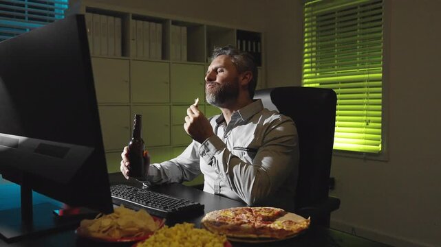 Business man night routine with laptop. Snack break during laptop work in office. Snack break for tired employee. Man rest in office with chips and pizza.