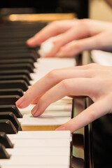 Fototapeta premium Close-up of a music performer's hand playing the piano. selective focus