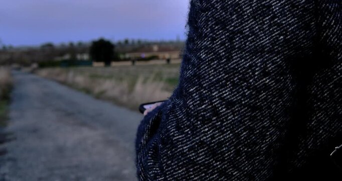 Solitude Stroll on Road: A lone figure, cloaked in a textured coat, takes a solitary walk along a path, surrounded by the tranquil ambiance of nature and the open air. 