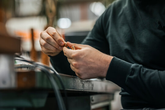 Midsection of male worker holding machine part working in factory