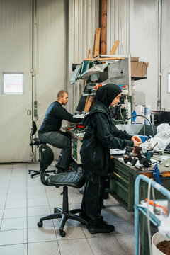 Full length of female plant worker assembling parts in factory