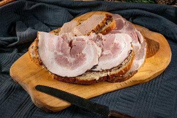 Sandwiches with cold meats on a board.