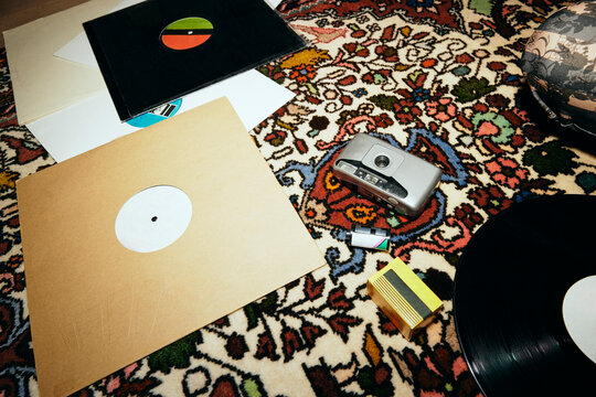 Film camera with old vinyl records on patterned carpet