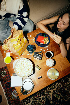 High angle view of man and woman eating junk food while sitting at home