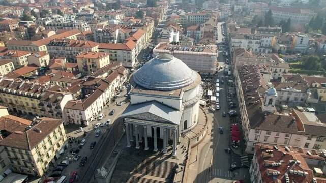 Aerial drone shot reveals the neoclassical Gran Madre di Dio church and surrounding historic city blocks in Turin, Italy, urban architecture, aerial heritage view, city panorama.