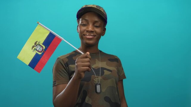 Woman holds ecuador flag steady in studio with teal backdrop while wearing military uniform and dog tags; patriotism.