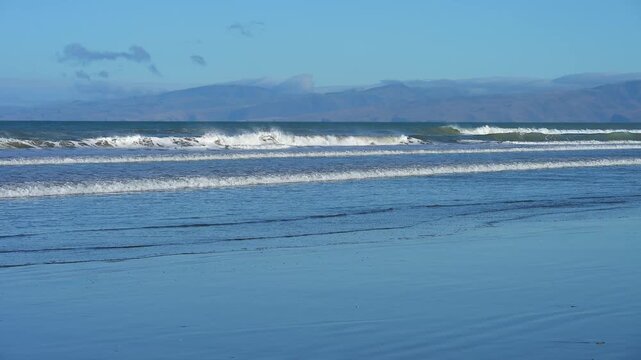 Klares blaues Meer vor einer entfernten Bergkulisse unter ruhigem Himmel, Spencer Park Beach, Spencerville, Christchurch, Neuseeland S&uuml;dinsel, Neuseeland, Ozeanien