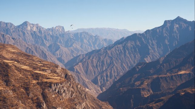 The mountains are covered in snow and the sky is clear. The mountains are very tall and the sky is very blue