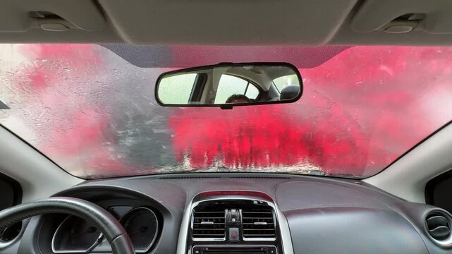 A driver's point of view inside a car wash. Front view