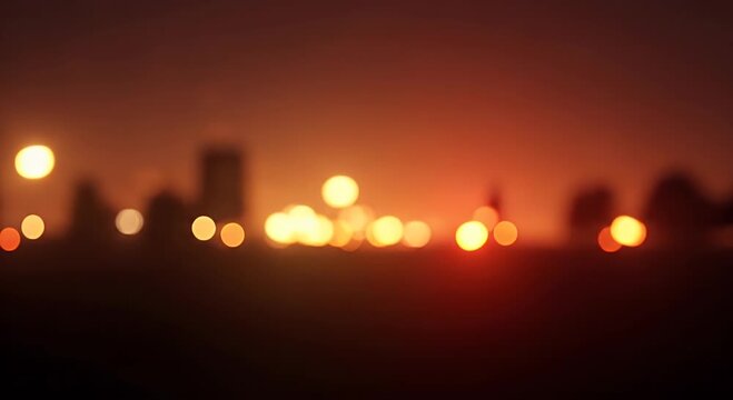 A soft focus, bokeh effect of city lights against a dusky orange and red sky