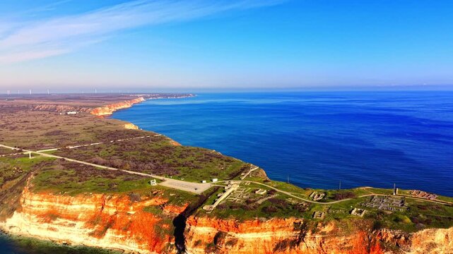 Aerial view of archaeological excavations and historical ruins on the rocky edge of Cape Kaliakra with the Black Sea coastline in Bulgaria.