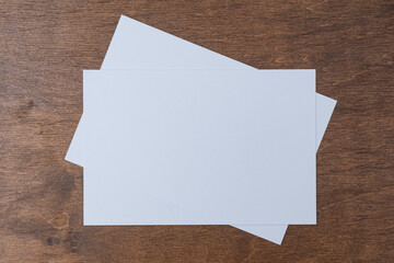 Blank horizontal postcard mockup placed on wooden table surface. Clean card template with copy space for business communication, marketing campaigns, corporate branding and promotional materials.