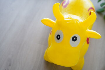 Children's toy in the form of a jumping cow. It is yellow in color.